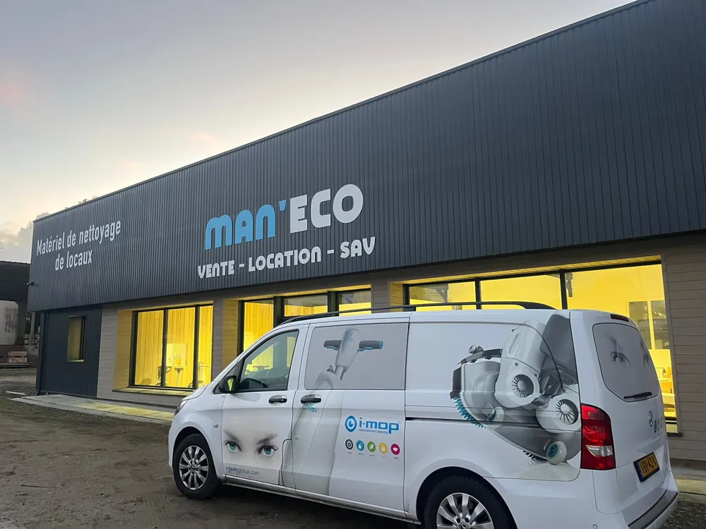 Le bâtiment Man'eco : bardage anthracite, enseigne MAN'ECO « Vente, location, SAV », et un utilitaire aux couleurs d'i-mop garé devant